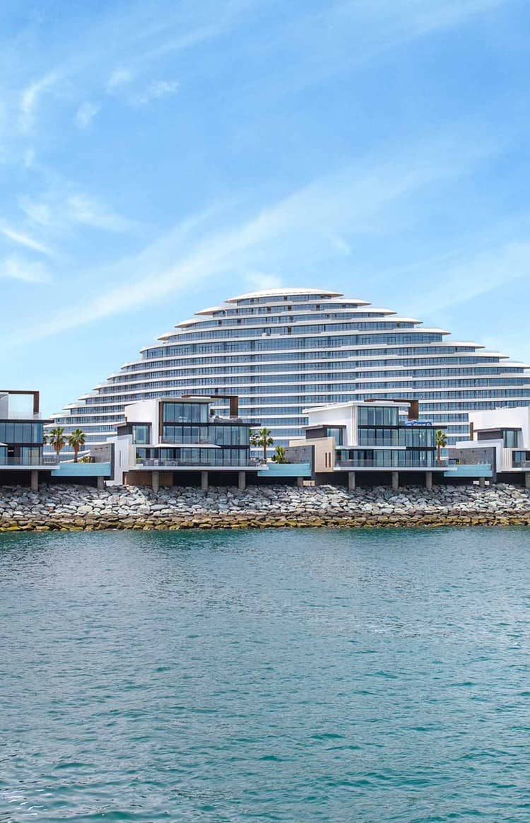 Dubai waterfront featuring the Burj Al Arab and a modern hotel overlooking the Arabian Gulf