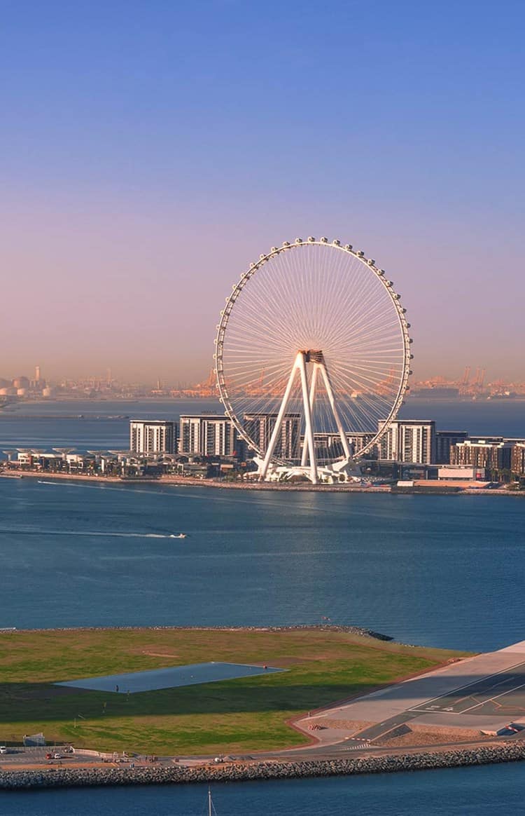 Dubai waterfront at sunset featuring Ain Dubai and surrounding skyline