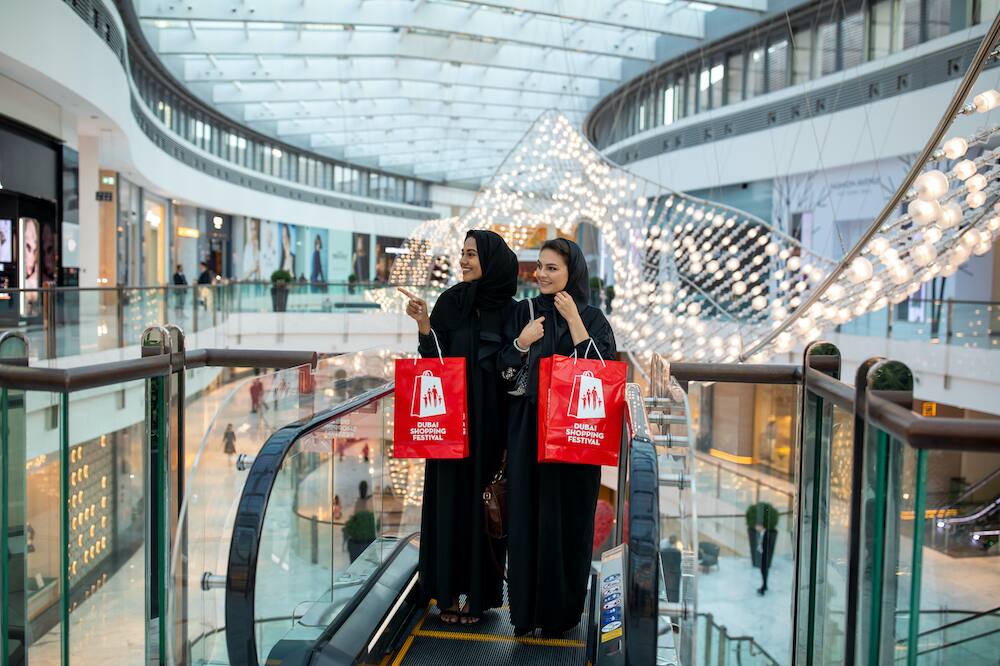 Shoppers carrying retail bags inside a modern shopping mall