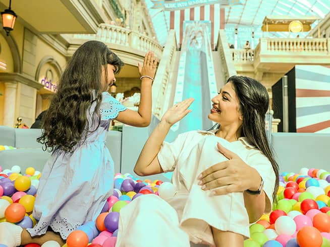Mother and daughter enjoying an indoor play area with colourful ball pits