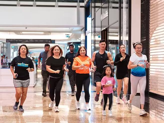 Group jogging together through a bright indoor walkway