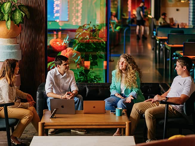 Business meeting between three professionals in a modern indoor workspace