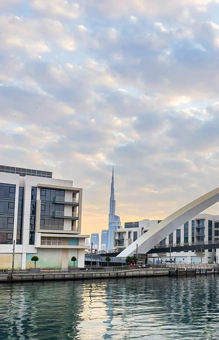 Waterfront view of Dubai with the Infinity Bridge and city skyline