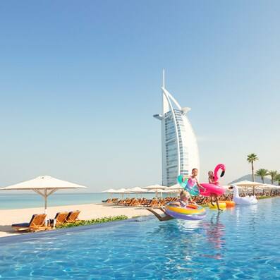 Kids playing in a pool in front of Burj Al Arab in Dubai
